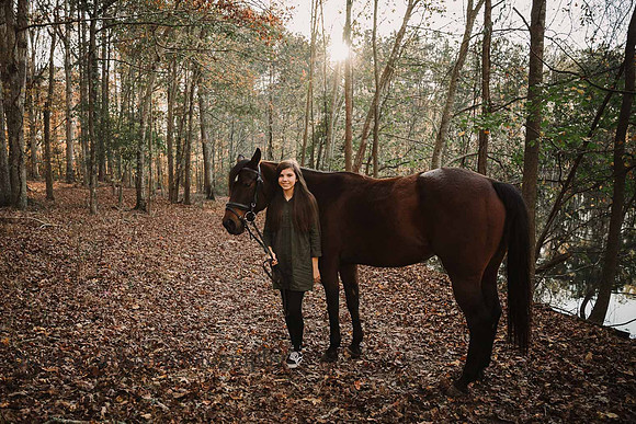 girl proudly stands with her horse