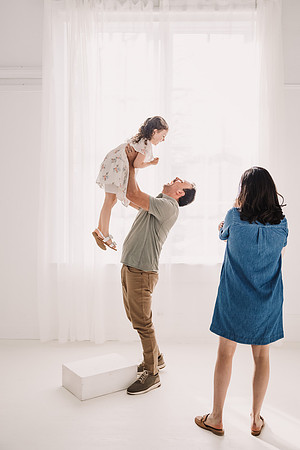 Dad lift four year old up in front of large window