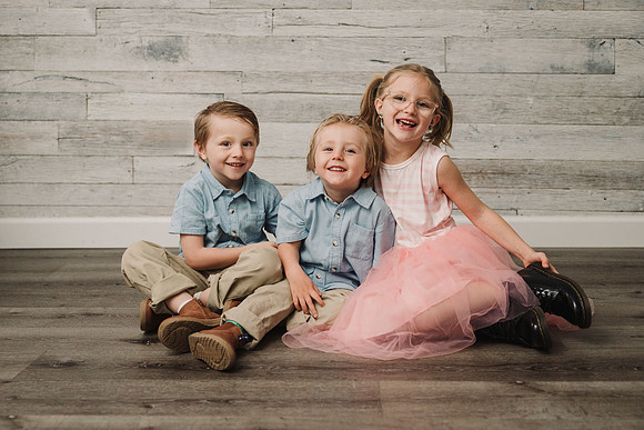 three young siblings smiling for a phot session