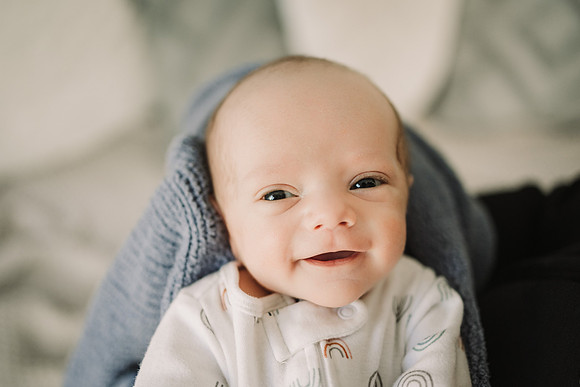 newborn baby smiles at the camera