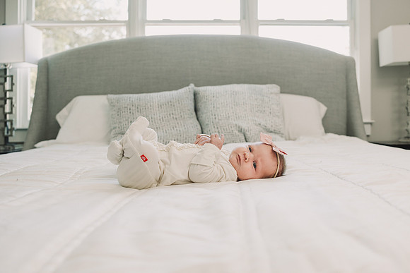 newborn baby laying on a large bed