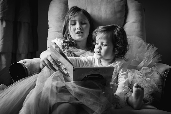 older sister reading to her younger sister