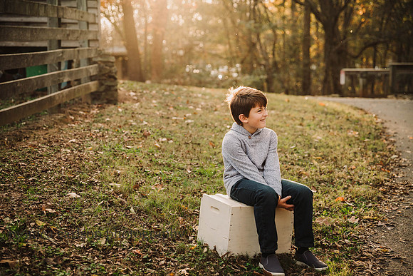 tween boy looks away while siting on a antique block in Duluth, GA