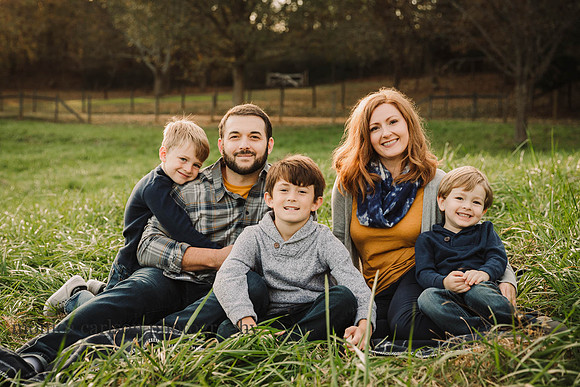 family of five siting on a blanket during a sunset session at McDaniel Family Farm