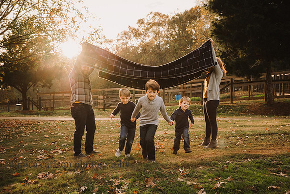 family of five play a game with a blanket during a family photo session