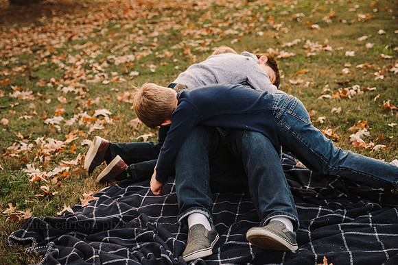 father is tackled by his three young sons by monica carlson photography