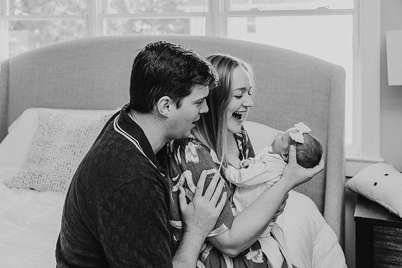 Happy young parents look proudly at their new baby