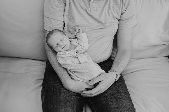 newborn boy held in fathers arms
