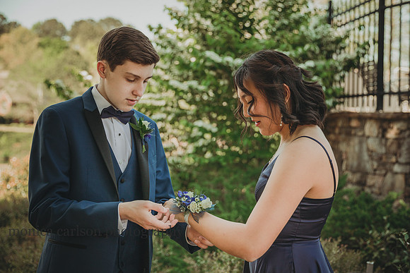 young man helps his date put on a corsage before a prom at Lambert High school
