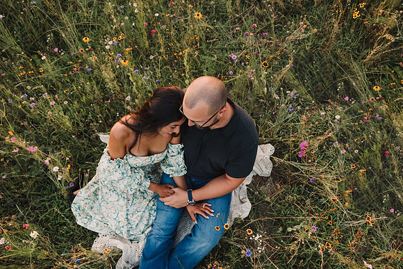 looking down at a couple snuggling on a flower field