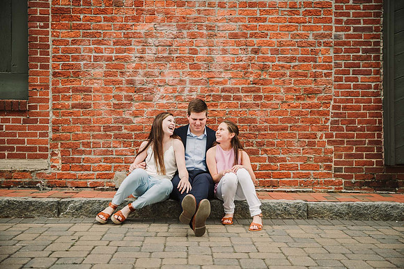 Three teens laughing together in front of a brick building in Marietta Square