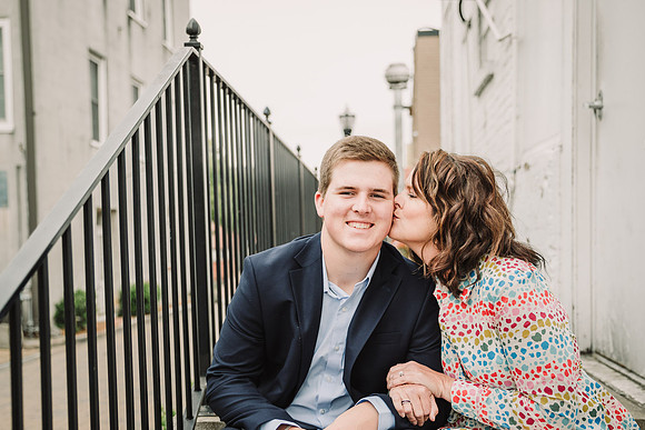 mother lovingly kissing her senior son on the cheek during a family photo session