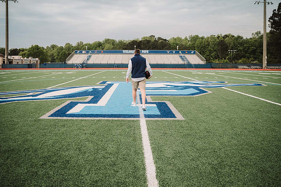 teen walking across the football field at Pope High school