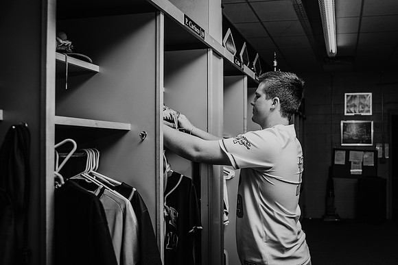 senior putting things in his locker by monica carlson