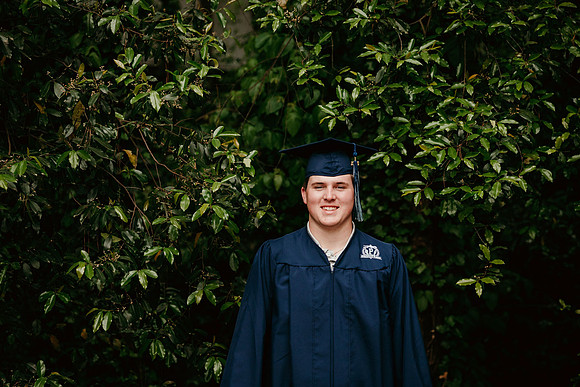senior boy smiling for a cap and gown image by monica carlson photography