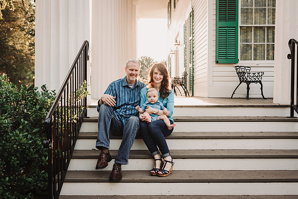 family of three siting on the patio at Barrington Hall during a family photo session