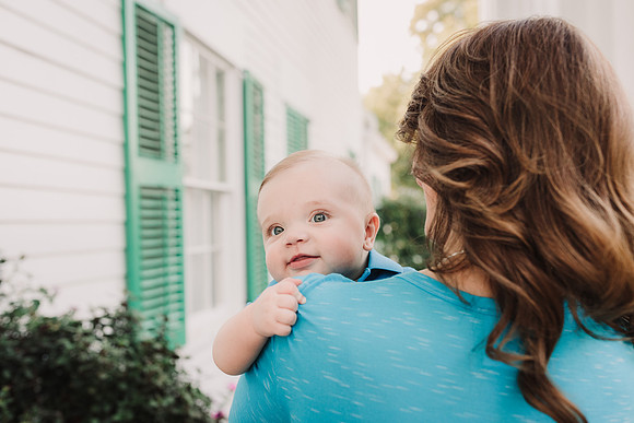 baby boy peeking over his mothers shoulder by monica carlson
