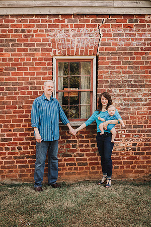 family of three standing in front of brick building in Roswell, GA