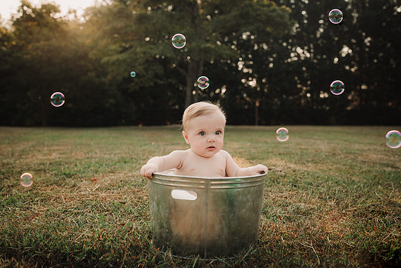 baby boy in a metal tub with bubbles surrounding him by monica carlson