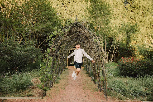 middle school boy running through a grape leaf tunnel at Barrington Hall