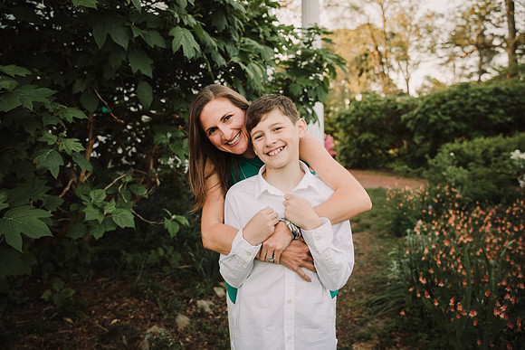 mothe hugs her happy tween son from behind