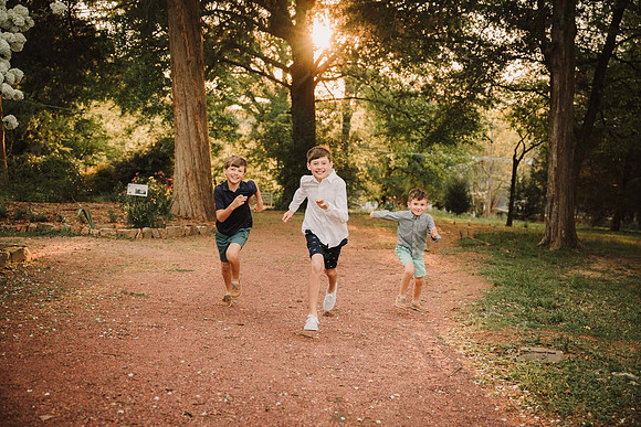 three brothers run through the grounds of Barrington hall during a family photo session