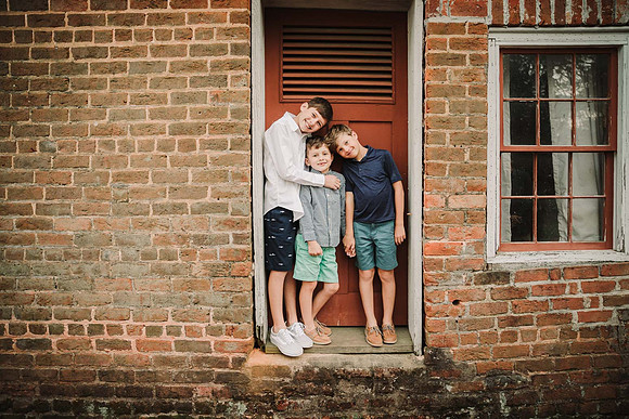 brothers standing in the door frame of the brick ice house on the grounds of Barrington Hall