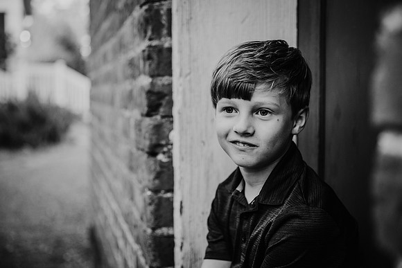 Black and white image of a boy in deep thought by monica carlson