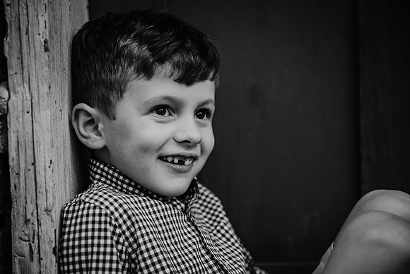 Black and white image of a boy who is missing his front tooth