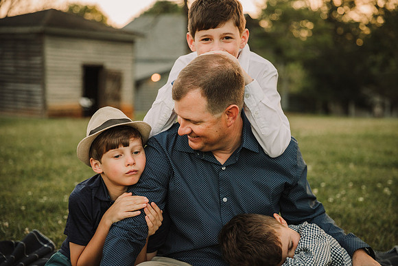 father and his sons sitting together on the lawn at barrington hall