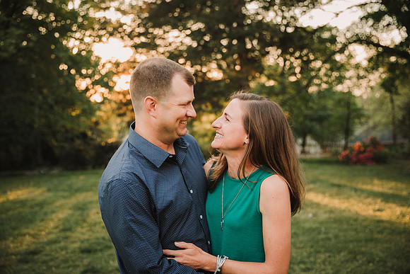 happy married couple smile at each other during a family photo session