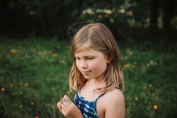 girl happily considers a wish she made on a dandelion