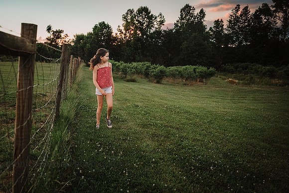tween girls walks at sunset along a fence at Prospect farms by monica carlson photography