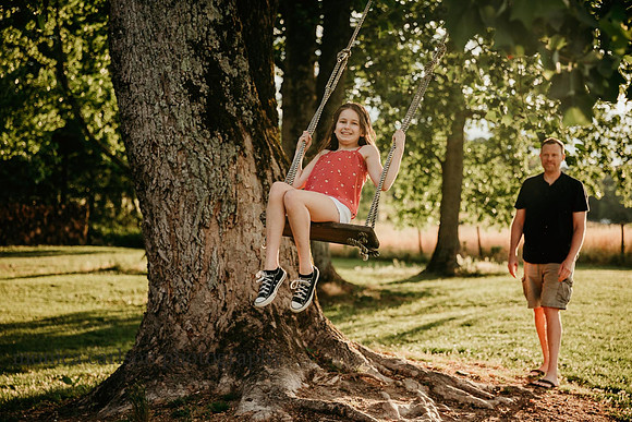 tween girl being pushed on a tree swing by her farm at Prospect farms