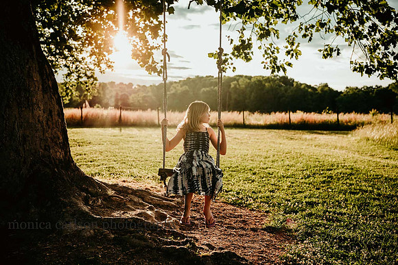 Young girl on a tree swing with the sun setting behind her by monica carlson photography