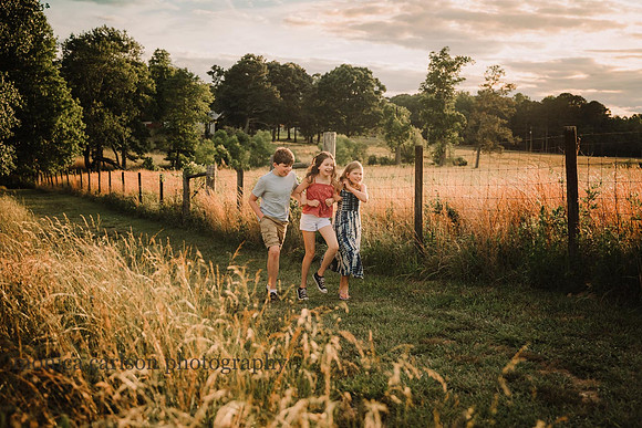 three siblings walking arm and arm on a farm in Lawerenceville, Ga
