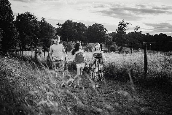 black and white image of three tween and teen siblings at Prosepct Farm