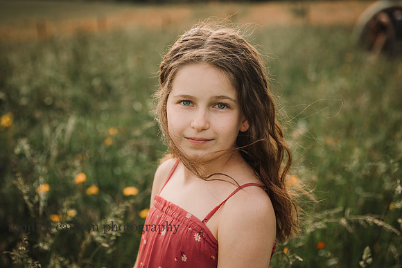 portrait of a blue eyed tween on a wildflower field by monica carlson photography