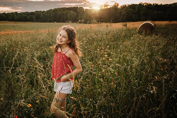 happy tween smiles while the sunsets on a whileflower field in Lawernceville, GA