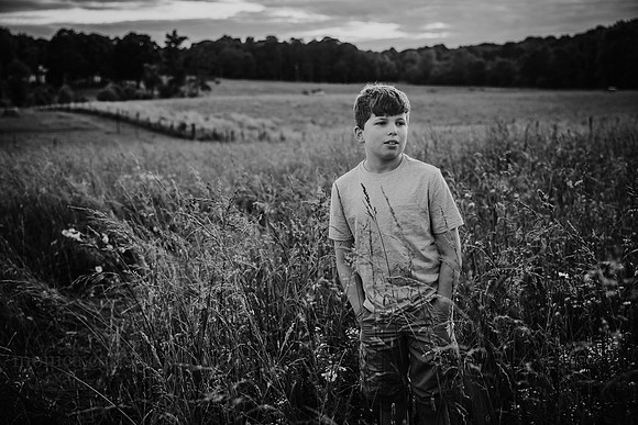 black and white image of a teen boy looking into the distance wihile on a field in Lawernceville