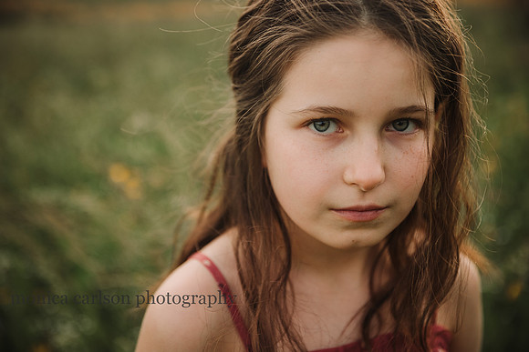 serious looking girl on a glowing field by monica carlson