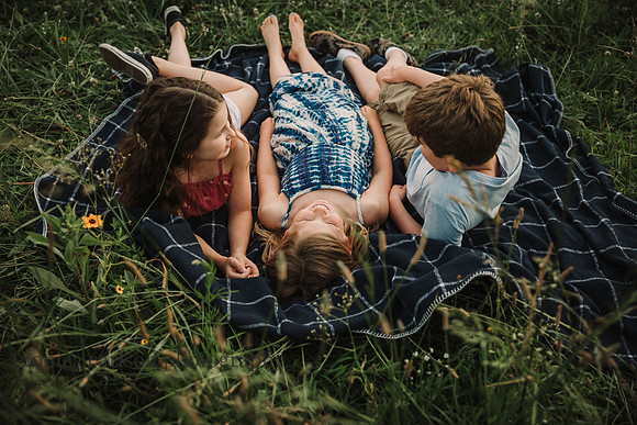 kids laying on a blanket on a flower field in lawernceville