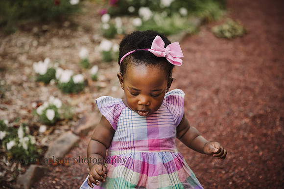 detailed image of baby in a pastel dress looking down