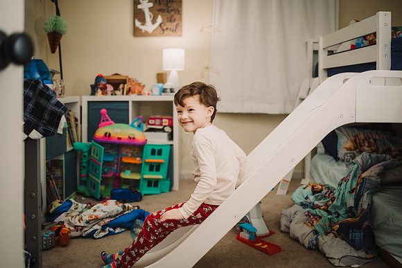 boy going down a slide in his room