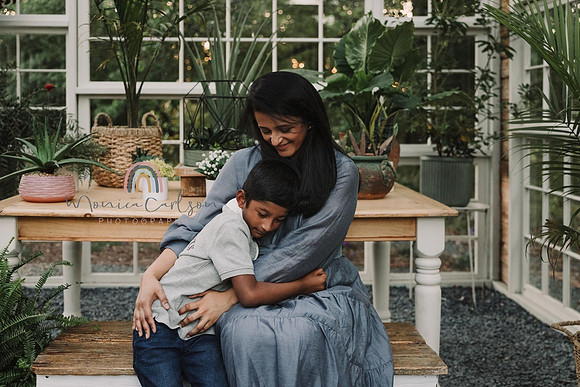 mom cuddles her young son in a the greenhouse at Prospect farms