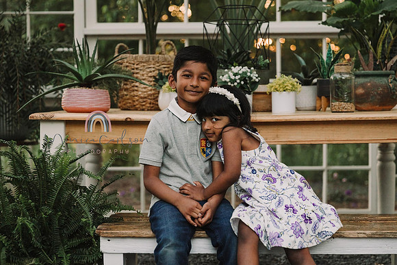 brother and sister hug inside the greenhouse at prospect farms by monica carlson
