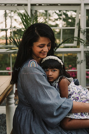 mother snuggles her three year old daughter in a reclaimed wood greenhouse in lawernceville, GA
