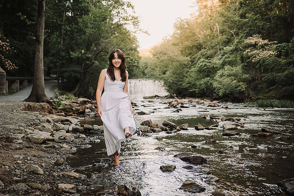 Lambert High school senior kicking water in front of waterfall in Roswell