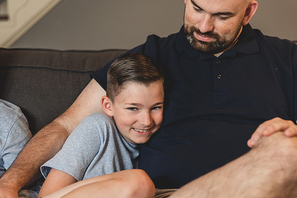 happy 5th grade boy laughs while his dad snuggles him by monica carlson photography