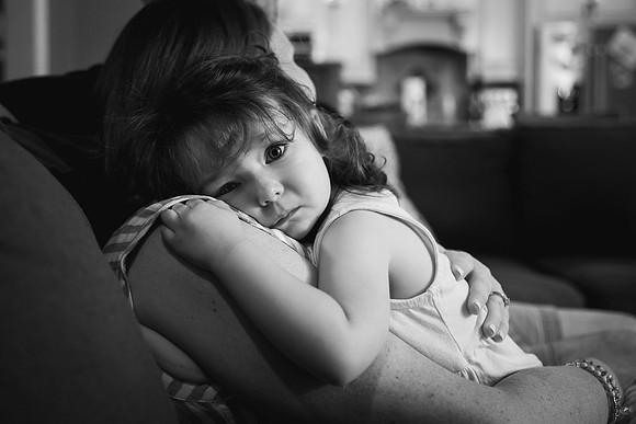 sad face of little girl being comforted by her mom